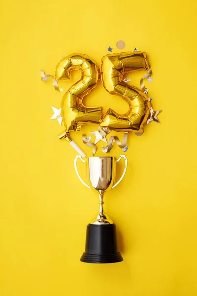Ballon de célébration de 25 ans d'or explosant d'un trophée gagnant — Photo
