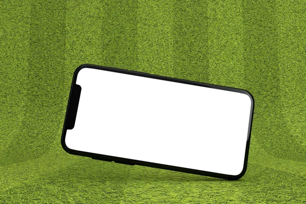 Smartphone com uma tela branca em branco em um campo de esportes verde. Renderização 3D — Fotografia de Stock