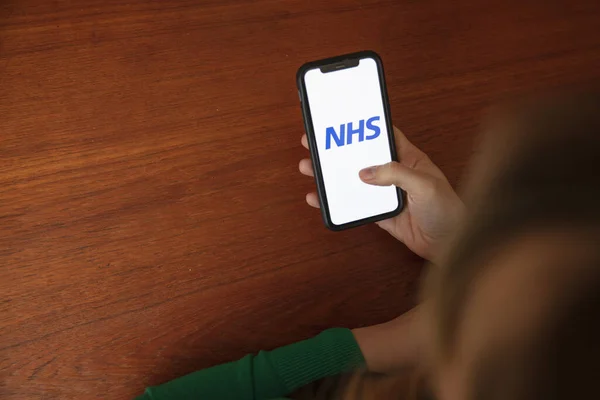 LONDRA, Regno Unito - 6 aprile 2020: Una persona che utilizza l'app per smartphone sanitaria NHS — Foto Stock