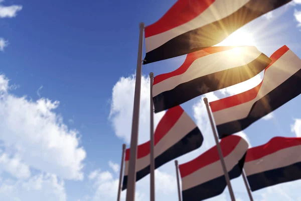Jemenské vlajky vlající ve větru proti modré obloze. 3D vykreslování — Stock fotografie