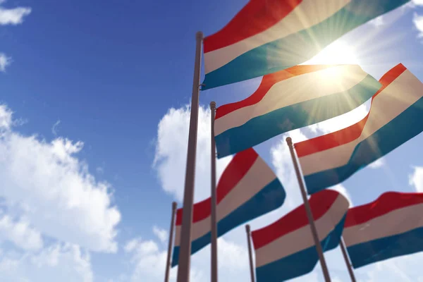 Luxemburgse vlaggen wapperen in de wind tegen een blauwe lucht. 3D-weergave — Stockfoto