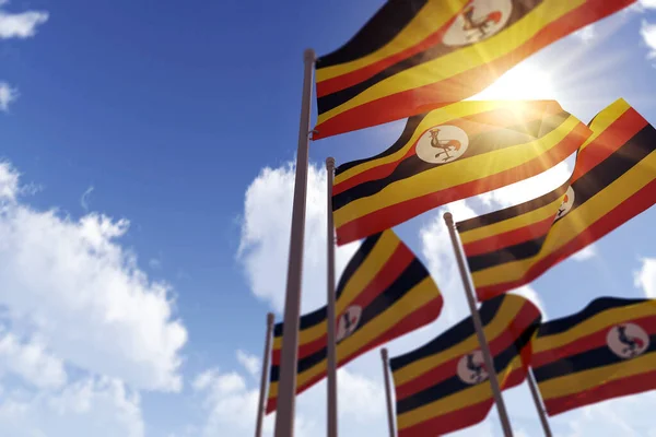 Bandiere dell'Uganda sventolano nel vento contro un cielo blu. Rendering 3D — Foto Stock