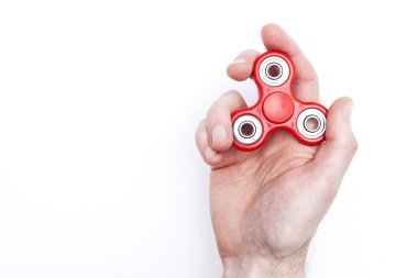 Erkek el, popüler hareketli döner oyuncağı tutuyor.