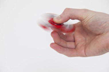 Erkek el, popüler hareketli döner oyuncağı tutuyor.