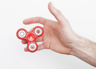 Erkek el, popüler hareketli döner oyuncağı tutuyor.