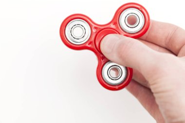 Erkek el, popüler hareketli döner oyuncağı tutuyor.