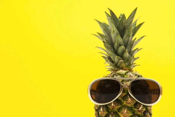 Sommar ananas frukt med solglasögon mot en ljust gul bakgrund — Stockfoto