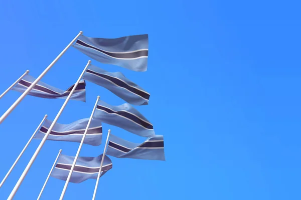 Σημαίες της Μποτσουάνα κυματίζουν στον άνεμο πάνω σε γαλάζιο ουρανό. 3D απόδοση — Φωτογραφία Αρχείου