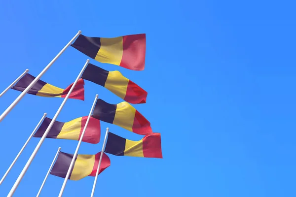Belgia macha flagami na wietrze nad błękitnym niebem. Renderowanie 3D — Zdjęcie stockowe