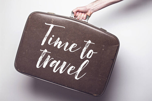 Time to travel to travel message on a vintage travel suitcase