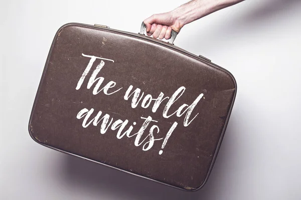 Die Welt wartet auf eine Botschaft auf einem alten Reisekoffer — Stockfoto