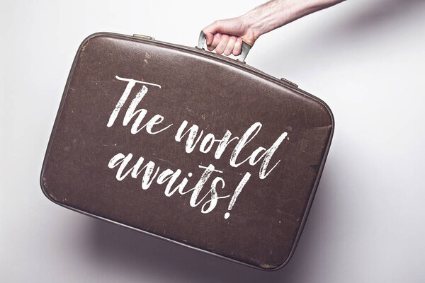 The world awaits message on a vintage travel suitcase