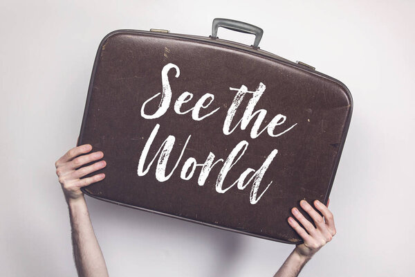 See the world message on a vintage travel suitcase