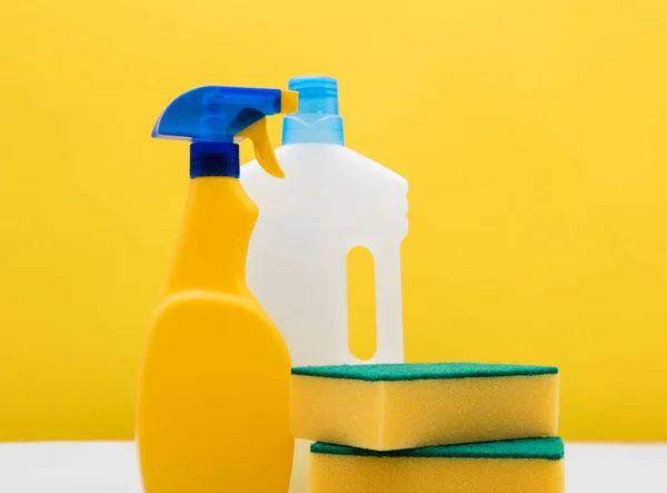 Čištění stříkací láhve a látky na jasně žlutém pozadí — Stock fotografie