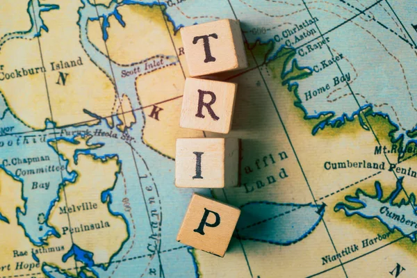 Trip word written in wooden blocks on a vintage travel map — Stock Photo, Image