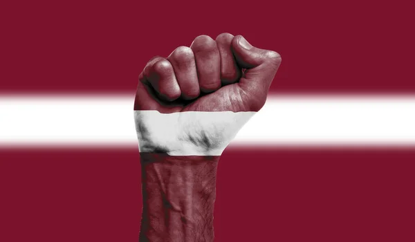 Latvia flag painted on a clenched fist. Strength, Protest concept — Stock Photo, Image