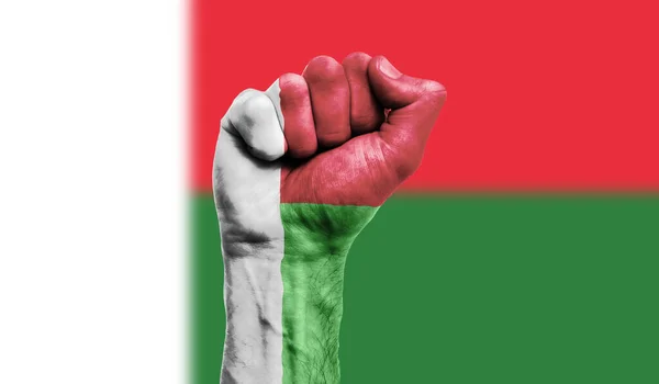 Madagaszkári zászló az ökölre festve. Erő, tiltakozás koncepció — Stock Fotó