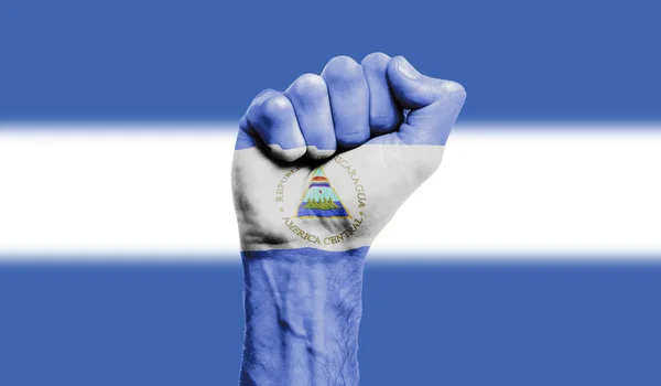 Drapeau du Nicaragua peint sur un poing serré. Force, concept de protestation — Photo