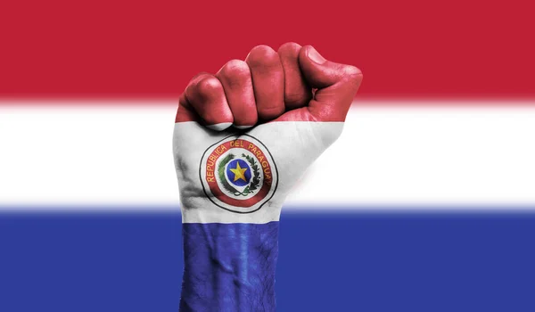挂在紧握拳头上的巴拉圭国旗。力量、抗议概念 — 图库照片