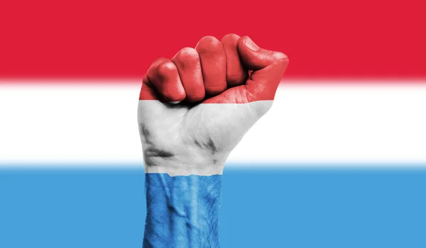 挂在紧握拳头上的卢森堡国旗。力量、抗议概念 — 图库照片