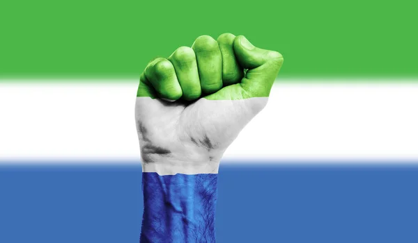 Serra Leoa bandeira pintada em um punho cerrado. Força, conceito de protesto — Fotografia de Stock