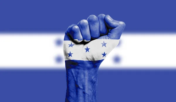 Прапор Гондурасу намальований на стиснутому кулаку. Сила, протести — стокове фото