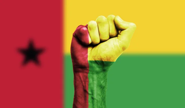Guinea-Bissau-Flagge mit geballter Faust. Stärke, Protestkonzept — Stockfoto