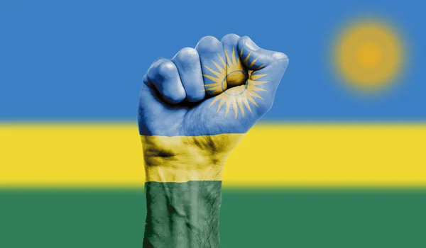 Прапор Руанди, намальований на стиснутому кулаку. Сила, протести — стокове фото