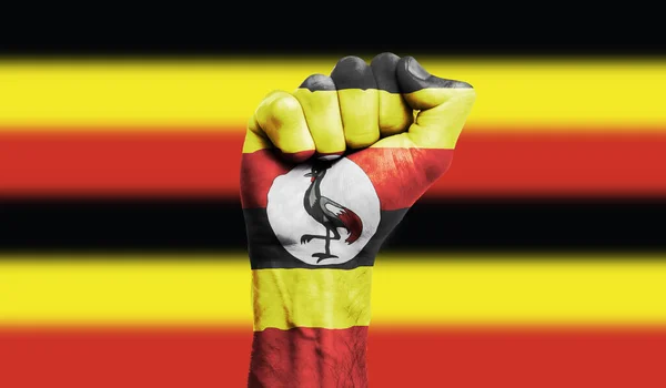 Bandiera Uganda dipinta su un pugno stretto. Forza, concetto di protesta — Foto Stock