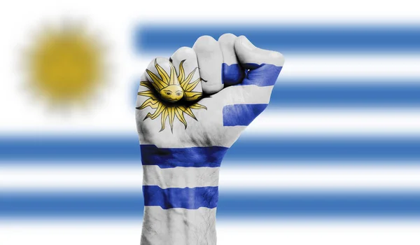 Прапор Уругваю намальований на стиснутому кулаку. Сила, протести — стокове фото
