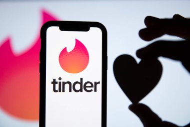 LONDON, İngiltere - 29 Nisan 2020: Kalp silueti olan bir telefonda Tinder flört logosu