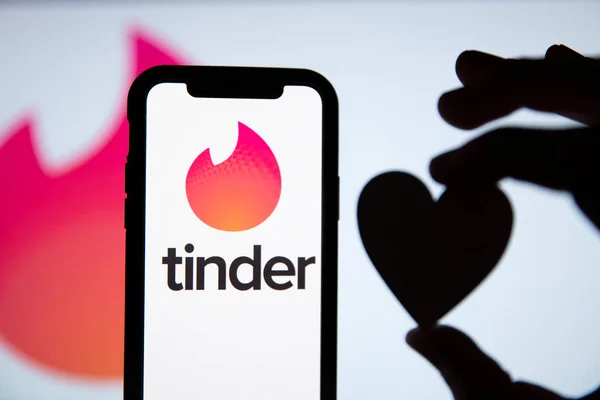 LONDRES, Reino Unido - 29 de abril de 2020: Tinder namoro logotipo em um telefone com silhueta de coração — Fotografia de Stock