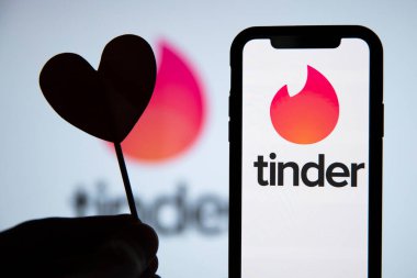 LONDON, İngiltere - 29 Nisan 2020: Kalp silueti olan bir telefonda Tinder flört logosu