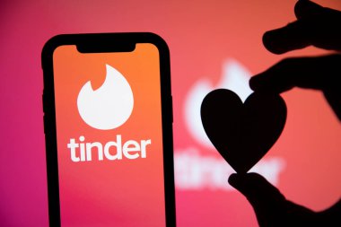 LONDON, İngiltere - 29 Nisan 2020: Kalp silueti olan bir telefonda Tinder flört logosu