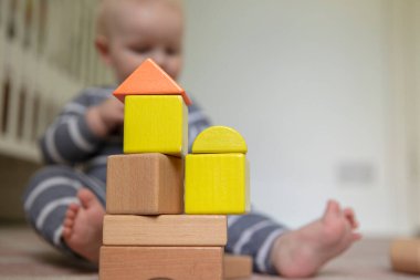 Çocuk odalarında renkli tahta bloklarla oynayan bir bebek.
