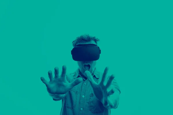 Muž po třicítce ve virtuální realitě ve sluchátkách. Grafický duotonový styl — Stock fotografie