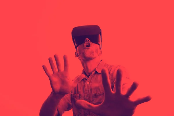 Muž po třicítce ve virtuální realitě ve sluchátkách. Grafický duotonový styl — Stock fotografie