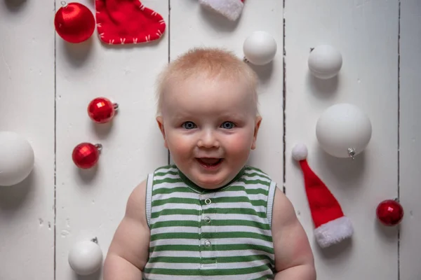 Happy baby w otoczeniu świątecznych dekoracji świętujących Boże Narodzenie — Zdjęcie stockowe