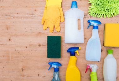 Temizleme sprey şişeleri ve bez düz bir kompozisyon yatıyordu ahşap arka planda
