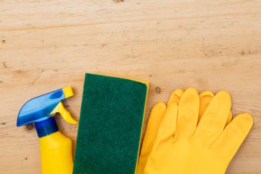 Temizleme sprey şişeleri ve bez düz bir kompozisyon yatıyordu ahşap arka planda