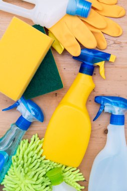 Temizleme sprey şişeleri ve bez düz bir kompozisyon yatıyordu ahşap arka planda