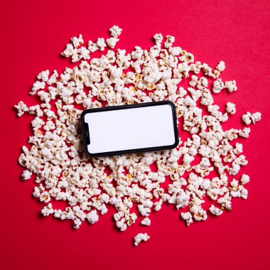LONDON, İngiltere - 14 Mayıs 2020: Elma iPhone boş ekran ve sinema patlamış mısır