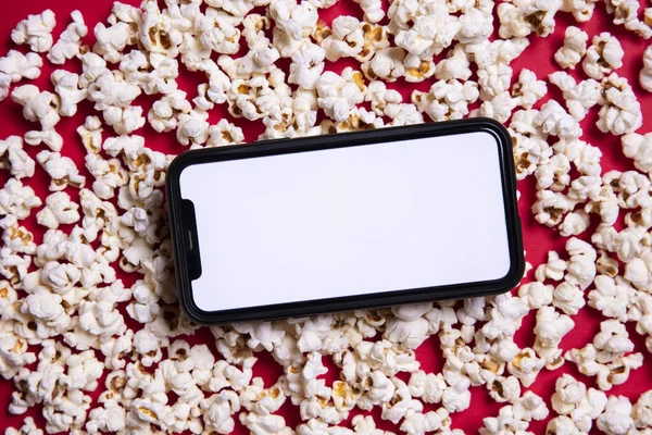 LONDON, İngiltere - 14 Mayıs 2020: Elma iPhone boş ekran ve sinema patlamış mısır