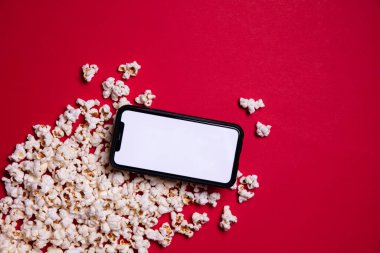 LONDON, İngiltere - 14 Mayıs 2020: Elma iPhone boş ekran ve sinema patlamış mısır
