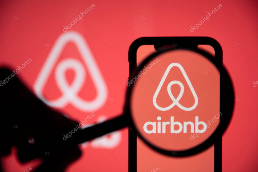 LONDON, UK - May 15 2020: Airbnb home rental logo under a magnifing glass