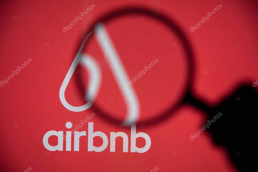 LONDON, UK - May 15 2020: Airbnb home rental logo under a magnifing glass