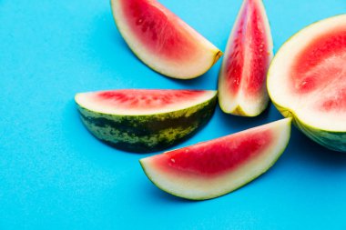 Parlak mavi arka planda taze dilimlenmiş karpuz.
