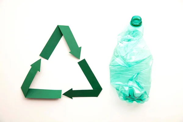 Символ переробки зеленого паперу з порожніми пластиковими пляшками води — стокове фото