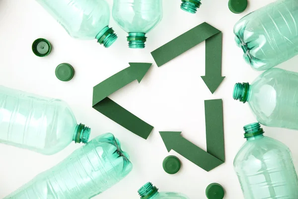 Grön papper återvinning symbol med tomma plastflaskor vatten — Stockfoto