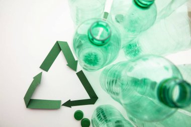 Boş plastik su şişeleriyle yeşil kağıt geri dönüşüm sembolü